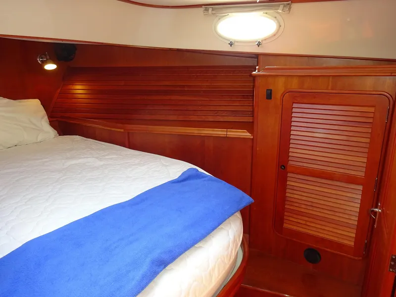 Slide: The Image of Cabin interior of 2002 Hinckley Talaria 44 FB with wooden paneling and cozy bedding. - 29
