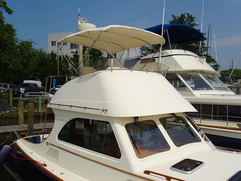 Slide: The Image of 2002 Hinckley Talaria 44 FB yacht docked, featuring a sleek design and flybridge canopy. - 5