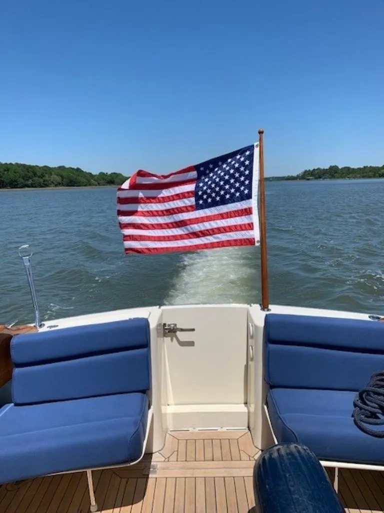 Slide: The Image of Hinckley Talaria 44 FB 2002 boat with American flag on open water. - 7