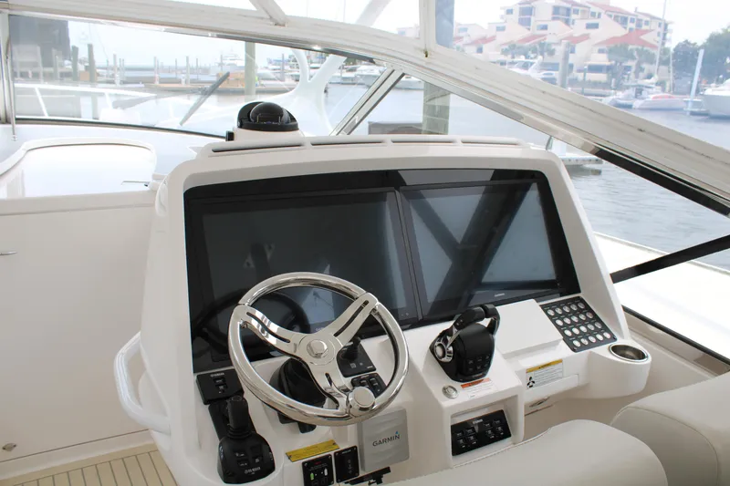 Slide: The Image of 2020 Intrepid 475 Sport Yacht helm with dual screens and steering wheel. - 12