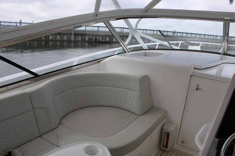 Slide: The Image of Interior of a 2020 Intrepid 475 Sport Yacht with plush seating and waterfront view. - 16