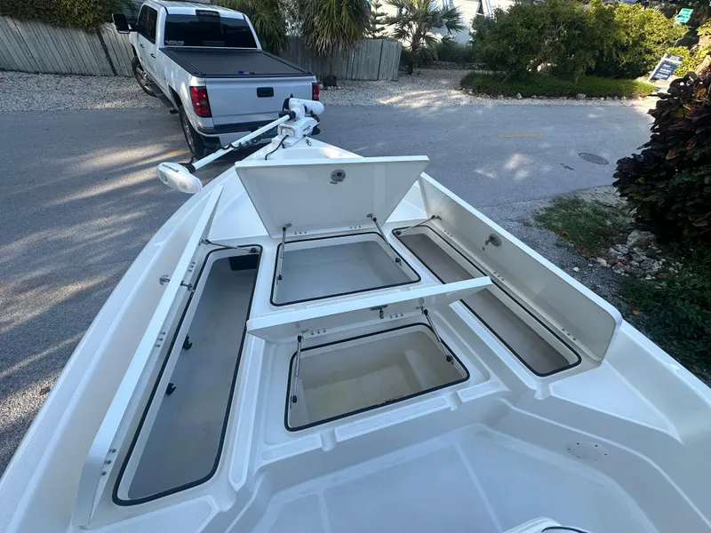 Slide: The Image of 2021 Skeeter SX 2250 boat with open storage compartments and a truck in the background. - 20