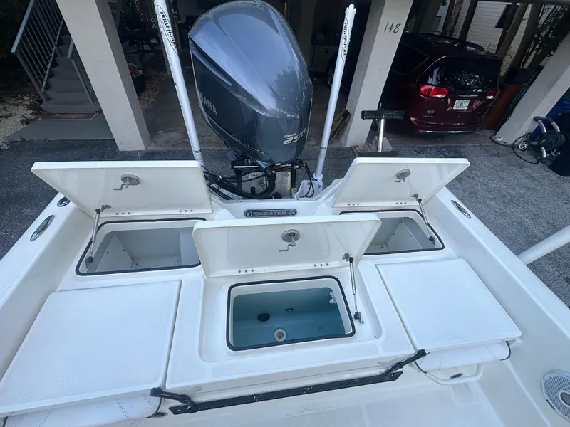 Slide: The Image of 2021 Skeeter SX 2250 boat with open storage compartments and Yamaha outboard motor. - 24