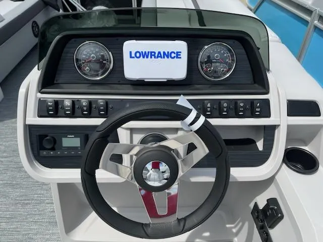 Slide: The Image of Sweetwater 2286C 2024 boat dashboard with Lowrance display and steering wheel. - 11