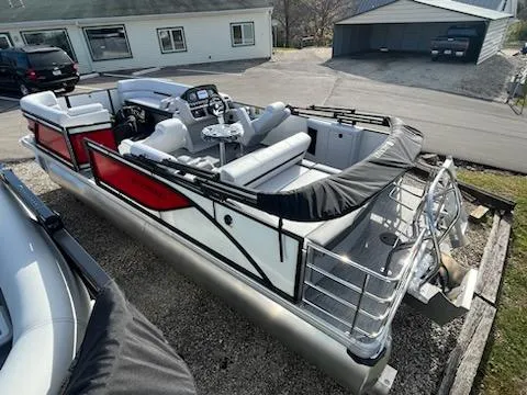 Slide: The Image of 2024 Godfrey 2286sfl pontoon boat with red and white design, parked on a trailer. - 17