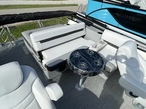 Slide: The Image of 2024 Godfrey 2286sfl boat interior with white seating and black table. - 9