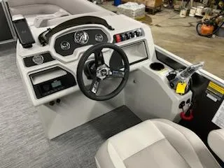 Slide: The Image of 2023 Godfrey 2286SBX boat dashboard with steering wheel and control panel. - 16