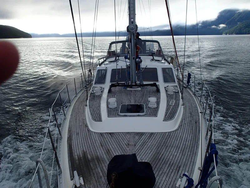 Slide: The Image of Sailing on a 1985 Nauticat 43 yacht in serene waters under a cloudy sky. - 1