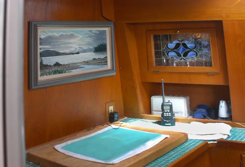 Slide: The Image of Interior of 1985 Nauticat 43 sailboat with wood paneling, artwork, and communication equipment. - 7