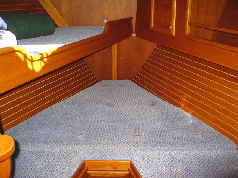Slide: The Image of Interior cabin of 1985 Nauticat 43 sailboat with wooden paneling and cushioned seating. - 9