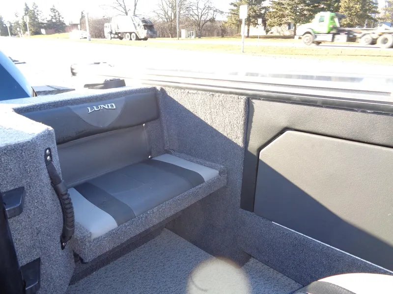 Slide: The Image of 2024 Lund 1875 Fisherman boat interior with gray seating and carpeted flooring. - 15