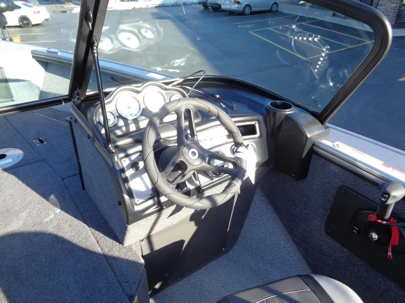 Slide: The Image of 2024 Lund 1875 Fisherman boat cockpit with steering wheel and dashboard controls. - 42