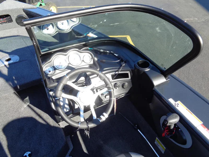 Slide: The Image of 2024 Lund 1875 Fisherman boat cockpit with steering wheel and dashboard controls. - 45
