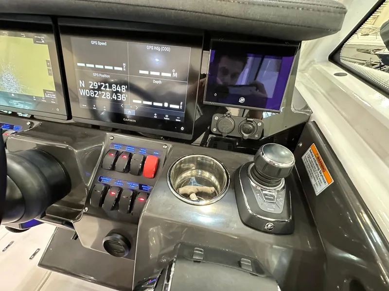 Slide: The Image of 2024 Blackfin 302 DC dashboard with GPS, controls, and cup holder. - 17
