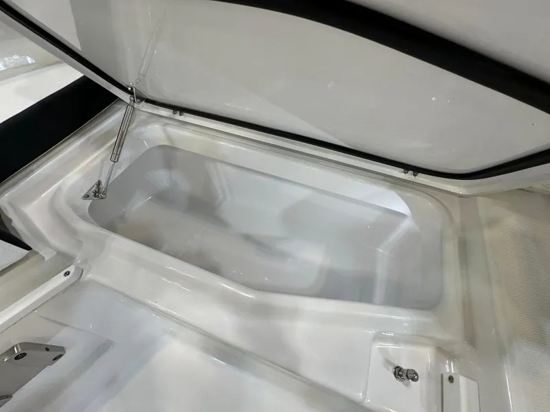 Slide: The Image of 2024 Blackfin 302 DC boat storage compartment, open lid, white interior. - 27