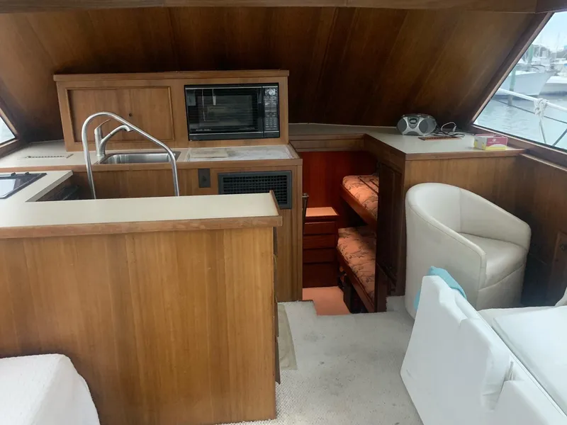 Slide: The Image of Interior of 1974 Hatteras 46 Convertible yacht with wood cabinetry and seating. - 12