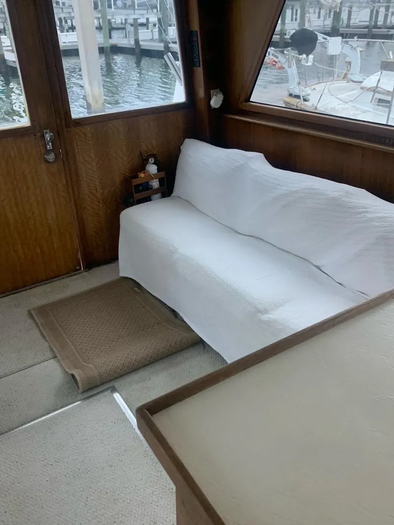 Slide: The Image of Interior of 1974 Hatteras 46 Convertible yacht with white sofa and marina view. - 15