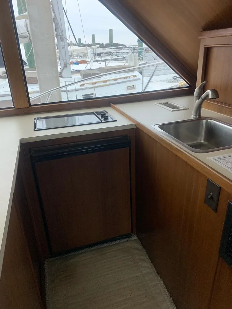 Slide: The Image of 1974 Hatteras 46 Convertible yacht kitchen with sink and stove, docked at marina. - 17