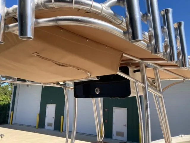Slide: The Image of 2014 Custom 24' Center Console boat with rod holders and canopy, docked near green building. - 11