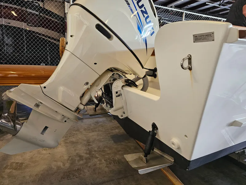 Slide: The Image of 2014 Custom 24' Center Console boat with Suzuki outboard motor in a garage. - 12