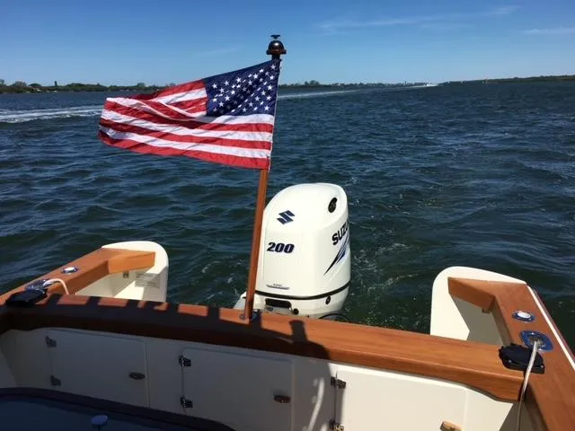 Slide: The Image of Custom 24' Center Console boat with American flag and Suzuki 200 engine on open water. - 3