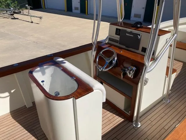 Slide: The Image of 2014 Custom 24' Center Console boat interior with wood accents and steering console. - 4