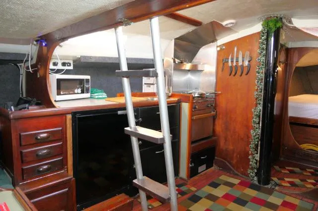 Slide: The Image of Interior of 1976 Choate Custom 38 sailboat with kitchen, ladder, and colorful flooring. - 14