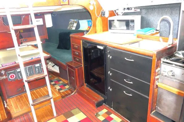 Slide: The Image of 1976 Choate Custom 38 yacht interior with kitchen, seating, and ladder. - 15