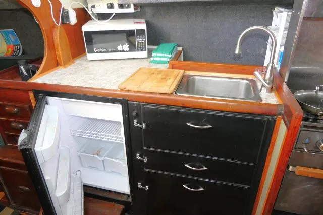 Slide: The Image of 1976 Choate Custom 38 yacht kitchen with sink, fridge, and microwave. - 17