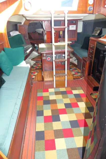 Slide: The Image of Interior of 1976 Choate Custom 38 sailboat with colorful rug and wooden furnishings. - 2