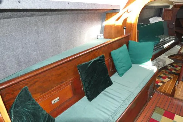 Slide: The Image of Interior of 1976 Choate Custom 38 sailboat with green cushions and wooden finish. - 3
