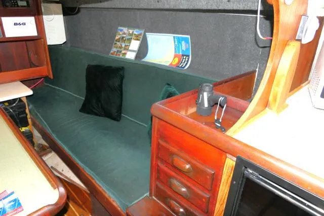 Slide: The Image of Interior of 1976 Choate Custom 38 sailboat with green sofa and wooden cabinetry. - 4