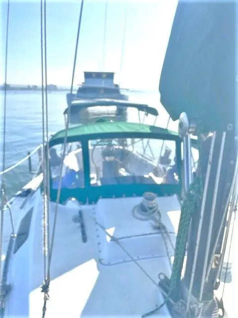 Slide: The Image of 1976 Choate Custom 38 sailboat with green canopy on calm water. - 42