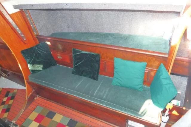 Slide: The Image of Interior of 1976 Choate Custom 38 sailboat with green cushions and wooden accents. - 5