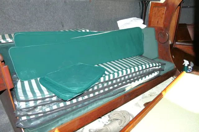 Slide: The Image of Interior of 1976 Choate Custom 38 sailboat with green-striped cushions and wooden accents. - 6