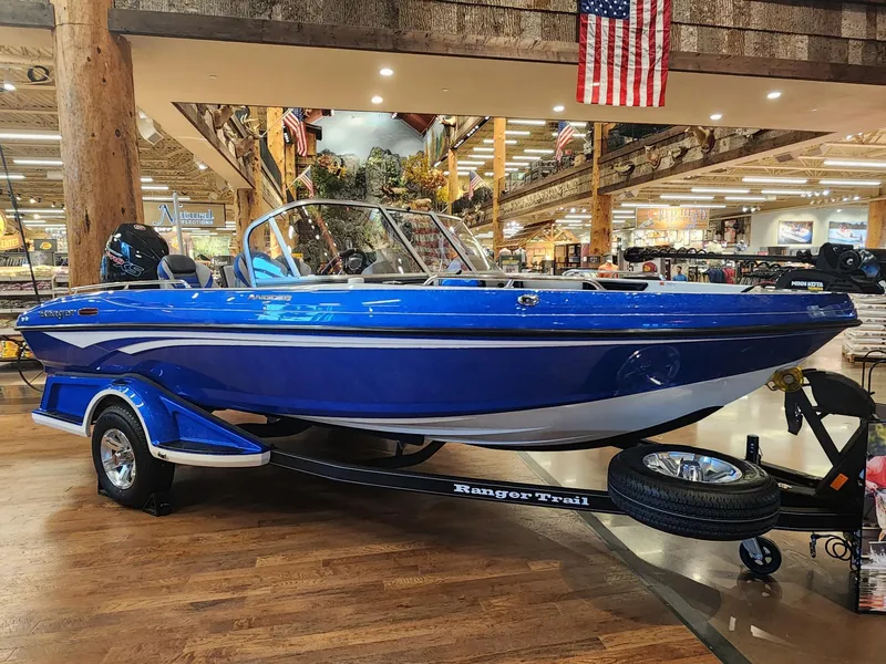 Slide: The Image of 2024 Ranger 1880MS blue boat on display indoors with trailer. - 2