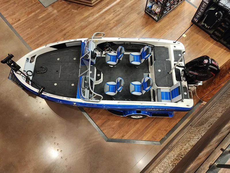 Slide: The Image of 2024 Ranger 1880MS boat with blue and white seats, displayed indoors. - 9