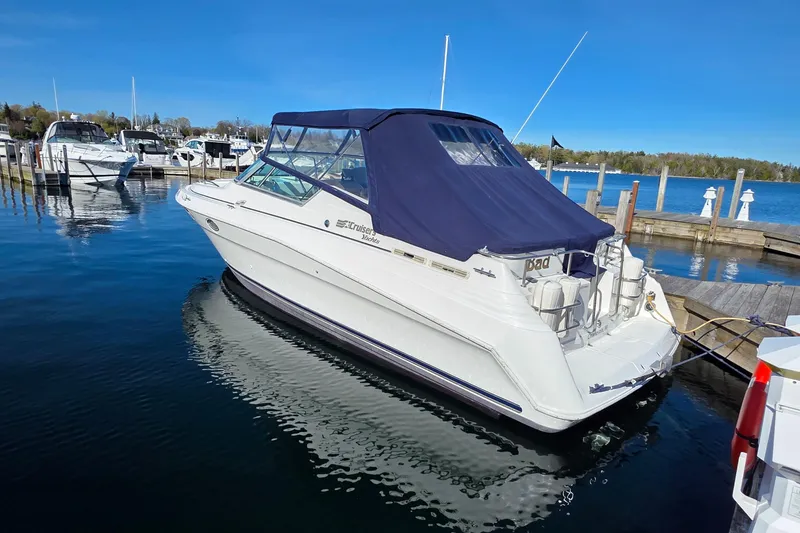 Slide: The Image of 1997 Cruisers Yachts 3120 Aria docked at a marina under clear blue skies. - 2