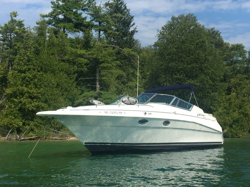 Slide: The Image of 1997 Cruisers Yachts 3120 Aria on calm water near trees. - 4
