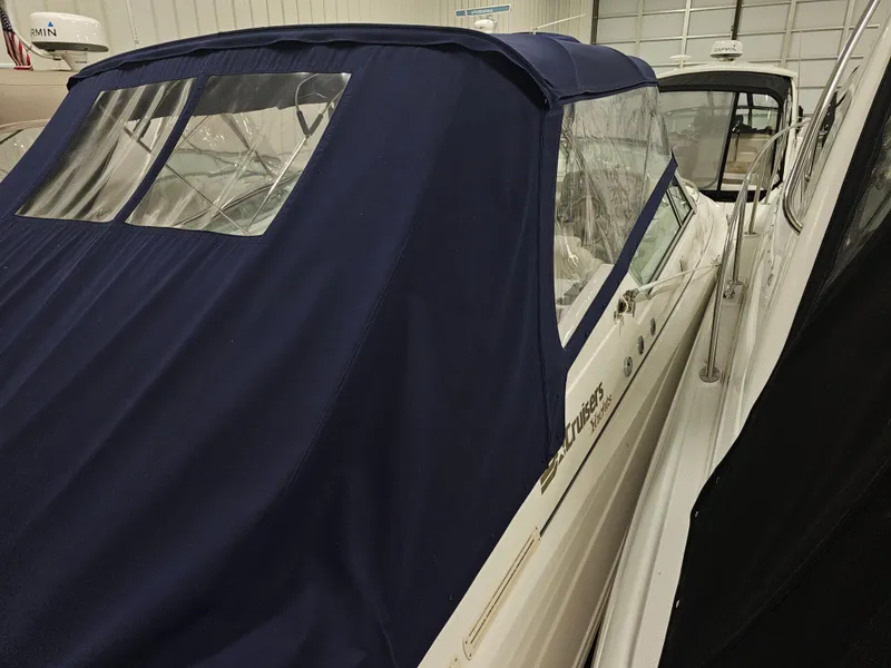 Slide: The Image of 1997 Cruisers Yachts 3120 Aria with blue cover in storage facility. - 9