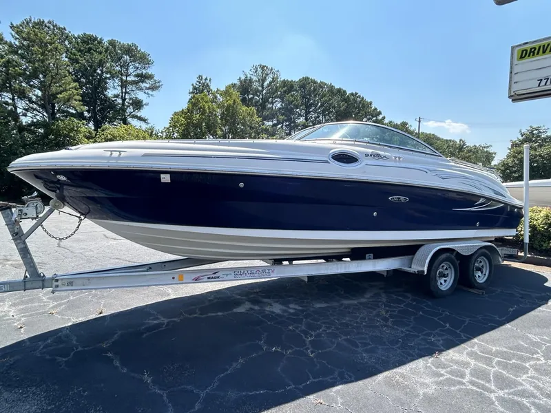 The Image of 2005 Sea Ray 240 SD boat on trailer, parked outdoors under clear sky. - 0