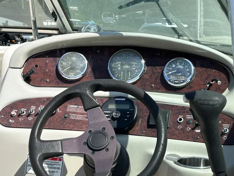 Slide: The Image of Dashboard of 2005 Sea Ray 240 SD boat with steering wheel and gauges. - 2