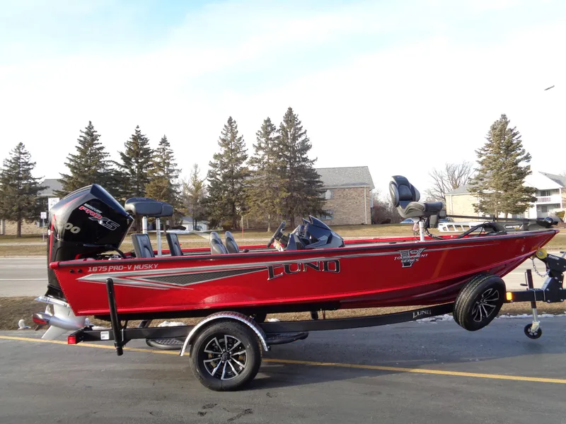 The Image of 2024 Lund 1875 Pro-V Bass boat in red on a trailer. - 0