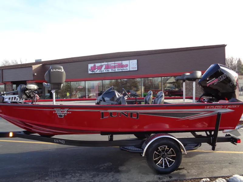 Slide: The Image of 2024 Lund 1875 Pro-V Bass boat in red, parked outside a dealership. - 14