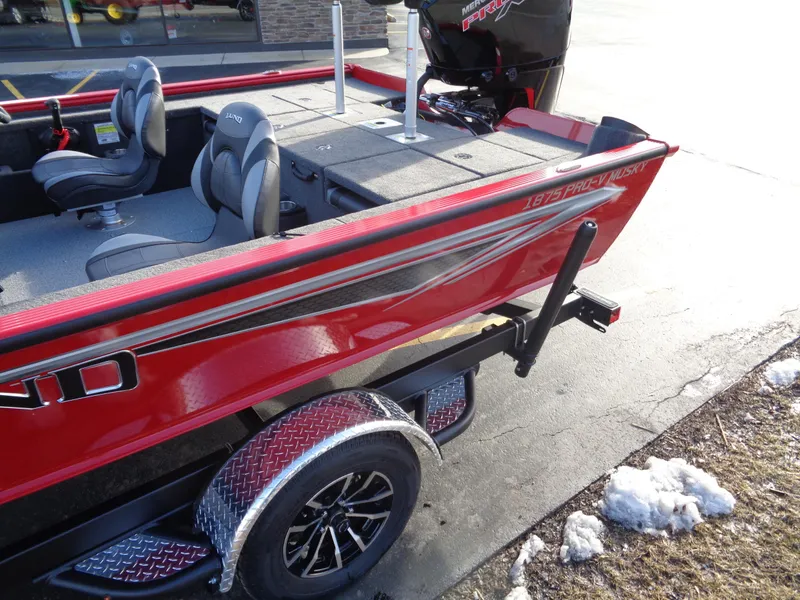 Slide: The Image of 2024 Lund 1875 Pro-V Bass boat in red, side view on trailer. - 15
