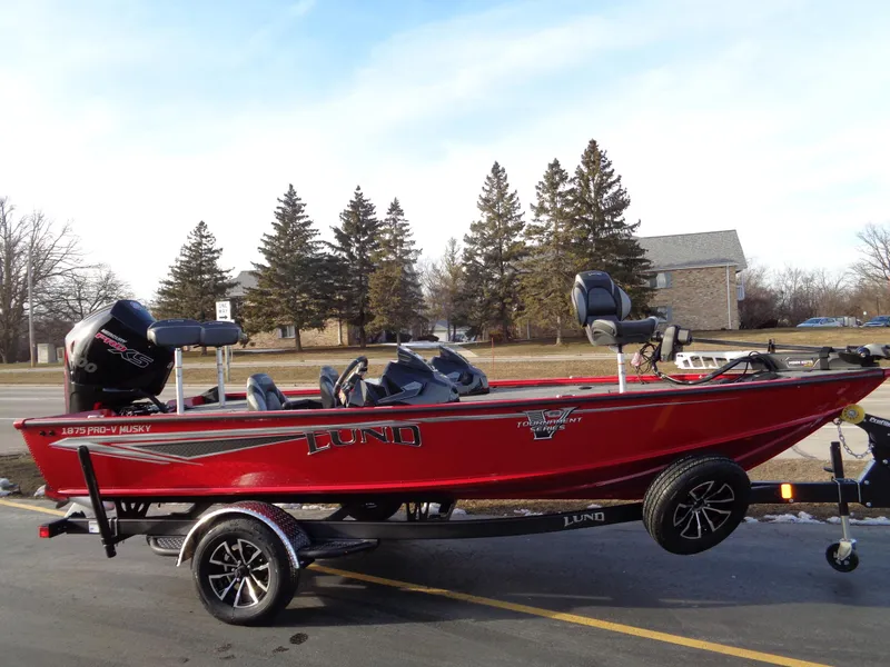 Slide: The Image of 2024 Lund 1875 Pro-V Bass boat in red on a trailer. - 7