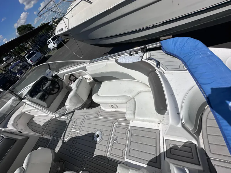 Slide: The Image of 2006 Yamaha Boats SX 230 interior with seating and steering wheel, docked at marina. - 19