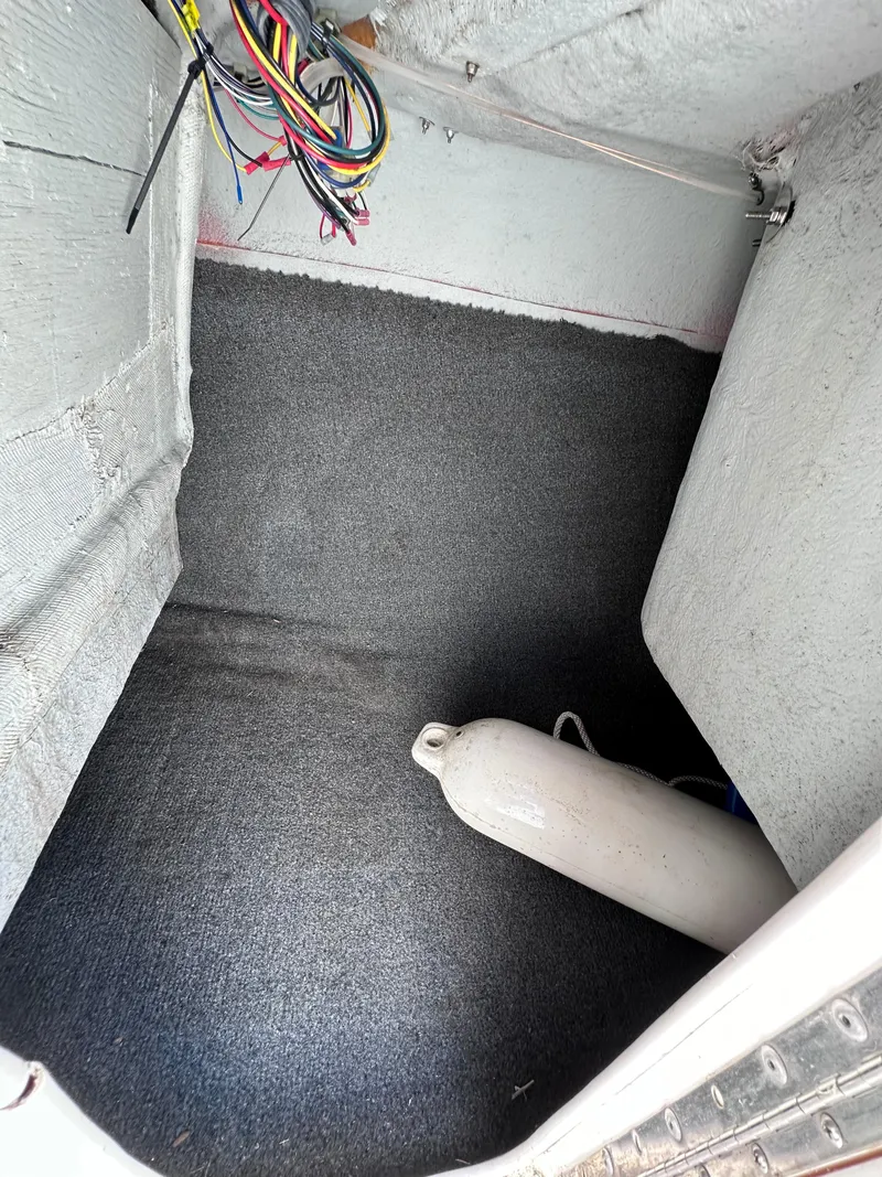 Slide: The Image of Storage compartment of a 2006 Yamaha Boats SX 230 with wiring and a boat fender. - 26