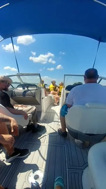 Slide: The Image of People relaxing on a 2006 Yamaha SX 230 boat under a blue canopy. - 35