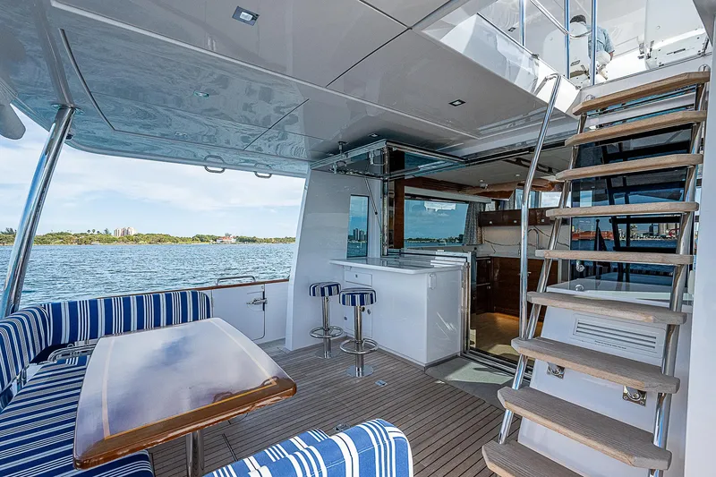 Slide: The Image of Luxurious 2022 Summit 54 Motoryacht interior with seating, bar stools, and staircase. - 18